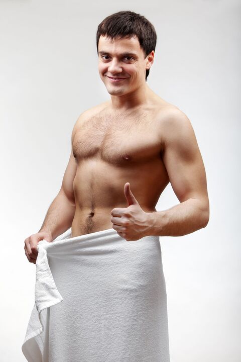 the man in the towel is satisfied with the increased size of his penis