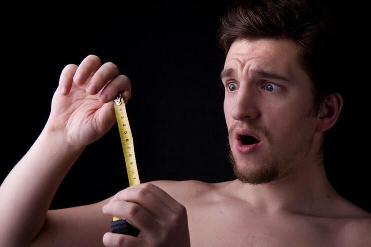 a man with a tape measure measured his penis before enlargement surgery